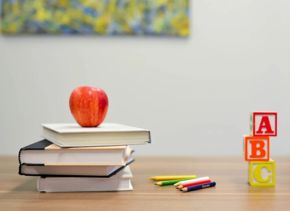 red apple fruit on four pyle books